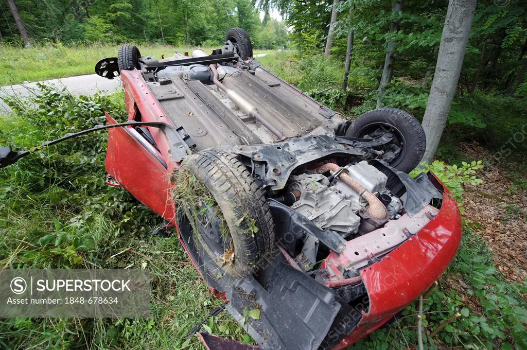 A damaged red Suzuki Swift is lying on its roof after a road traffic accident on the K 1209 road, Lichtenwald, Baden-Wuerttemberg, Germany, Europe