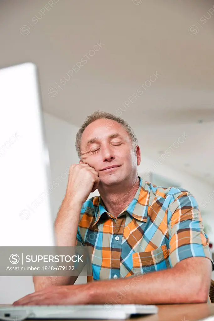 Man sitting in front of a computer, sleeping