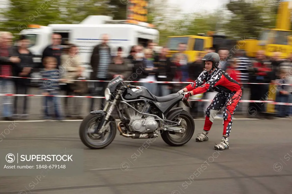 Motorcycle stuntman Mike Auffenberg being drawn by his motorcycle, Koblenz, Rhineland-Palatinate, Germany, Europe