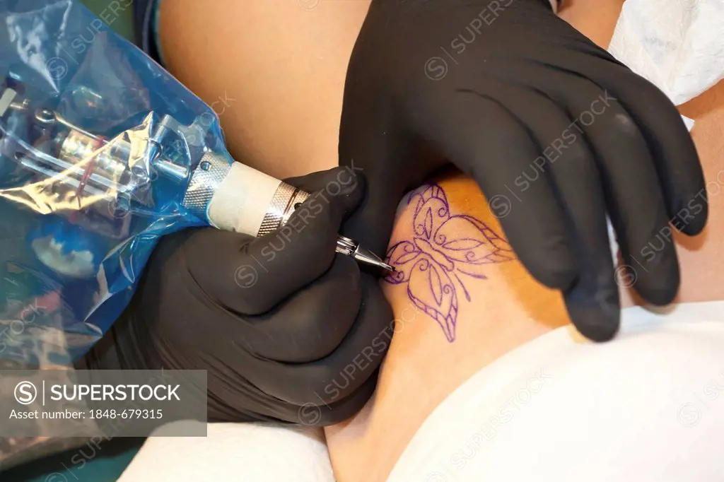 Tattooing the outline of a butterfly