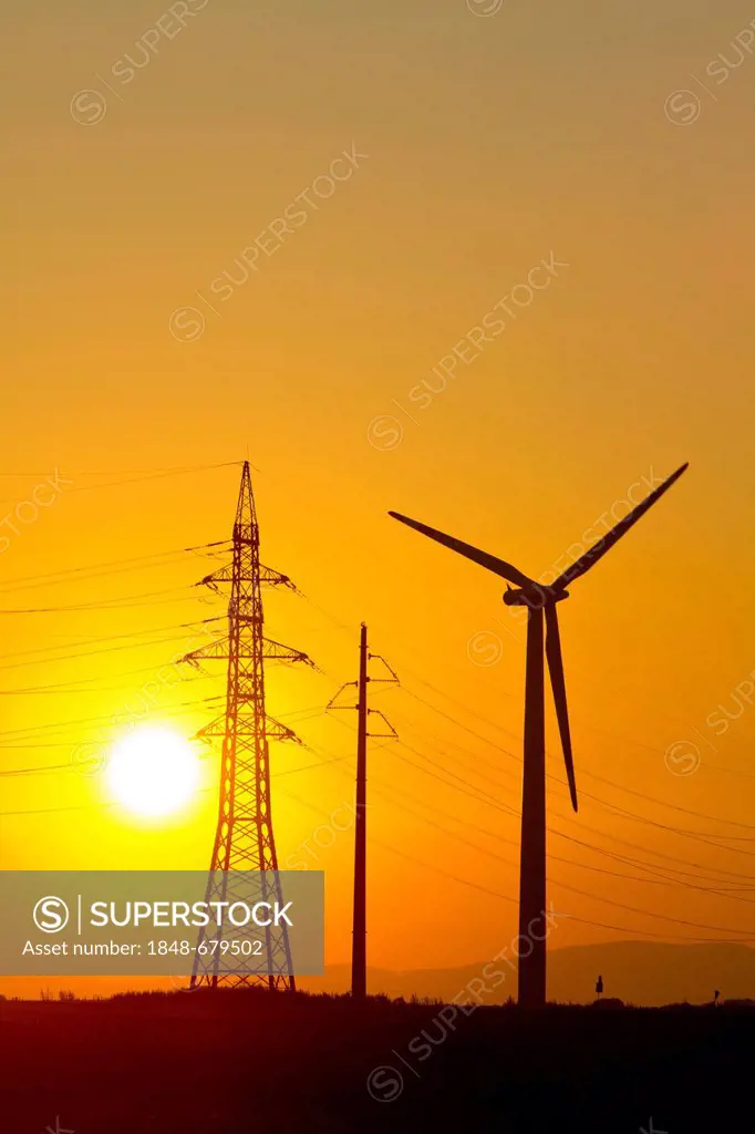Wind turbine and electricity pylons against sunset, Marchfeld, Lower Austria, Europe