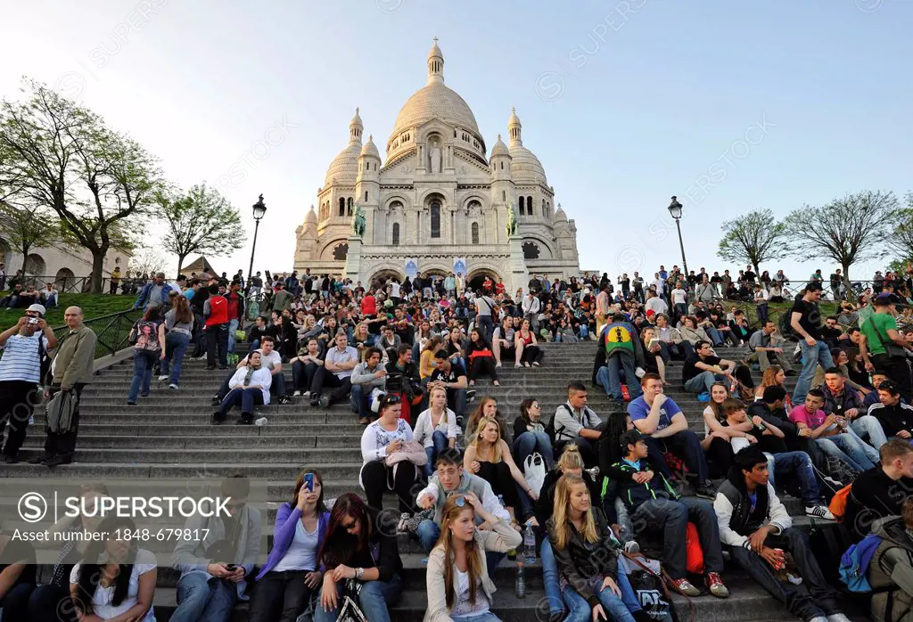 Tourists on steps in front of the Basilica of the Sacred Heart of Paris or Sacré-Cur Basilica, Montmartre, Paris, France, Europe