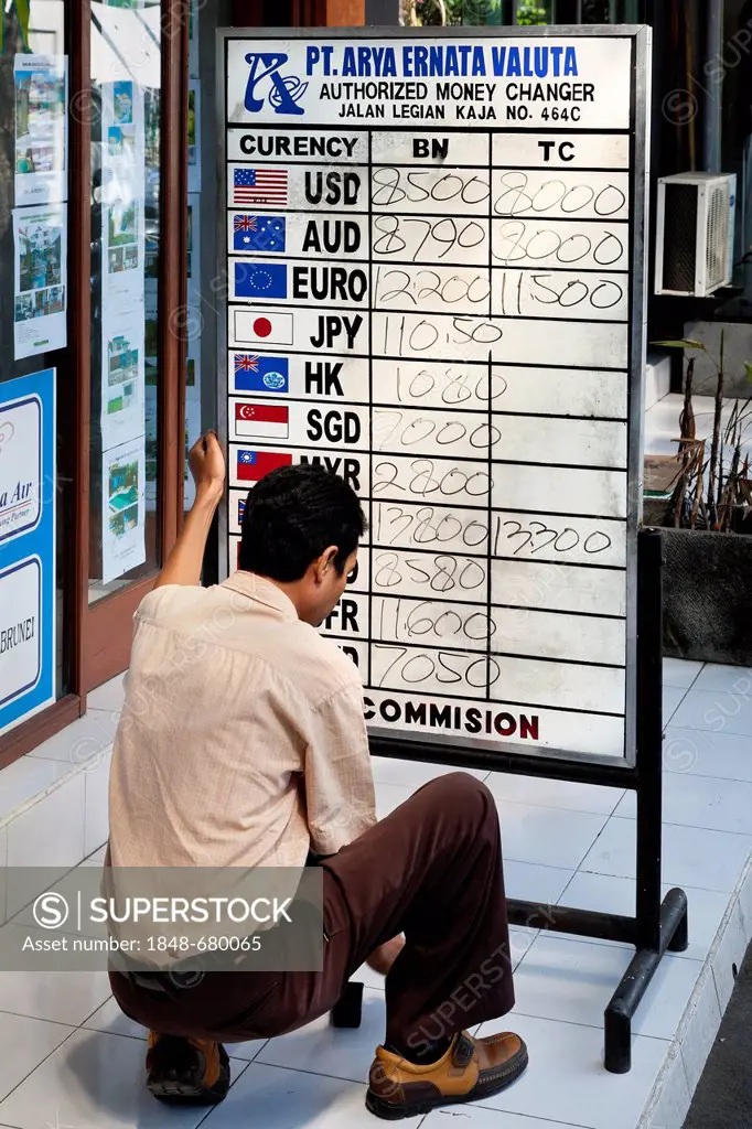 Man reading exchange rates on a board, Kuta, southern Bali, Bali, Indonesia, Southeast Asia, Asia