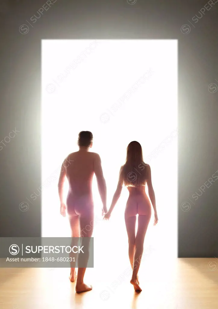 Nude young couple, back view, going through a door into the light