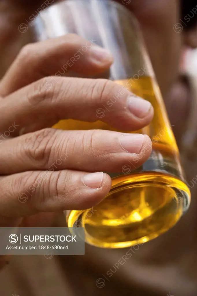 Hand holding a glass of cider