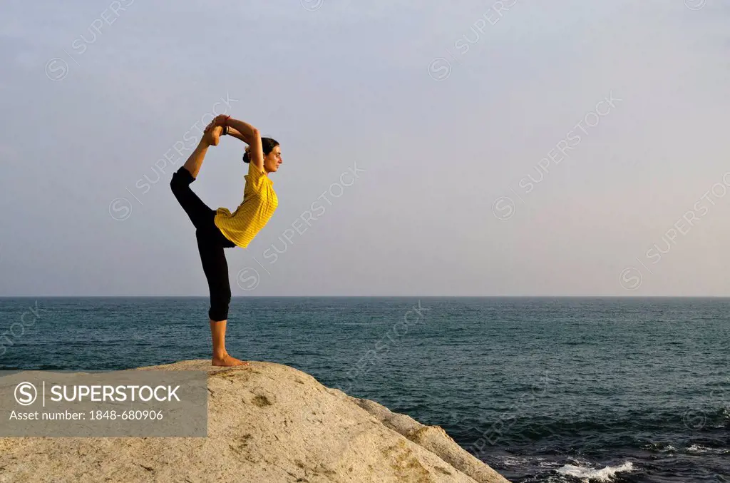 Woman in a yoga position, Natarajasana, by the sea in Kanyakumari, Tamil Nadu, India, Asia