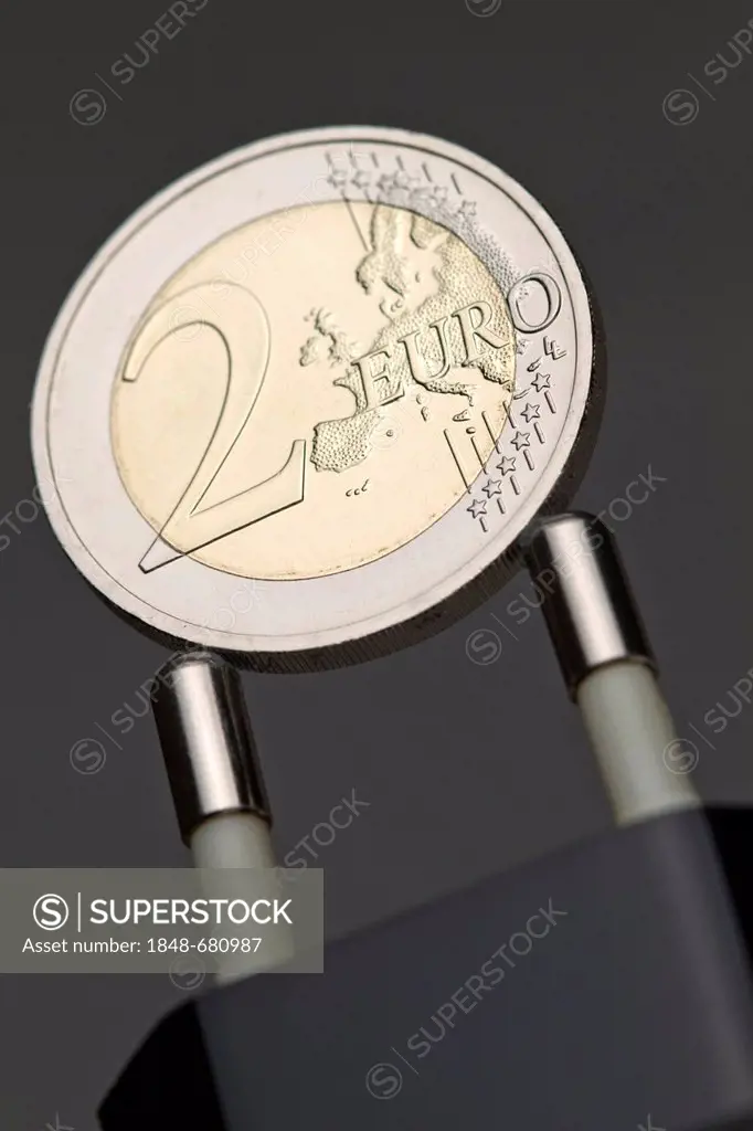 Two-euro-coin on a power plug, symbolic image for electricity rates