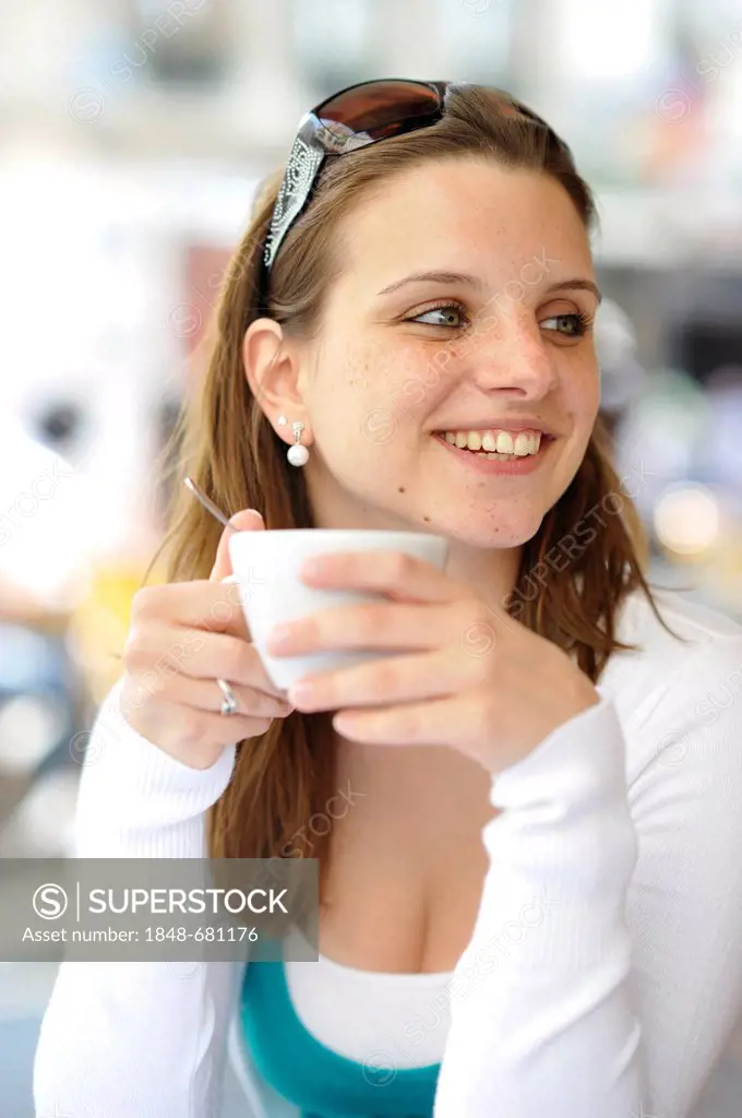 Young woman holding a coffee cup in a cafe, Paris, France, Europe