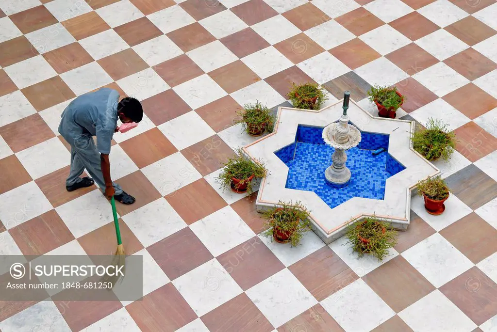Employee swepting the courtyard, Heritage Hotel Laxmi Vilas Palace, Bharatpur, Rajasthan, North India, India, Asia