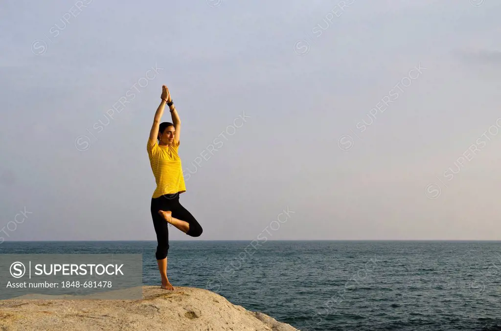Woman in a yoga position, Vrikshasana, by the sea in Kanyakumari, Tamil Nadu, India, Asia