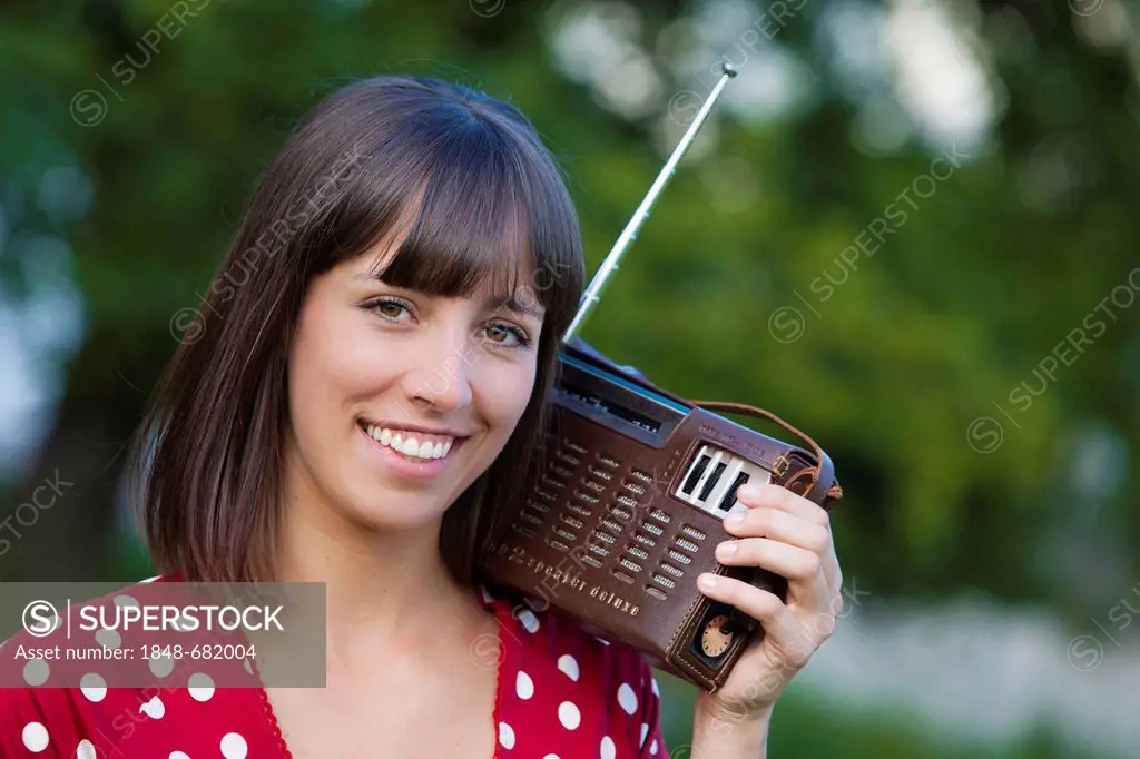 Young woman, 25, holding an old radio