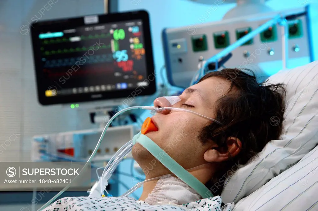 Patient lying in a special bed, intubated, medical appliances for medical treatment and artificial respiration of the patient, automatic monitoring of...