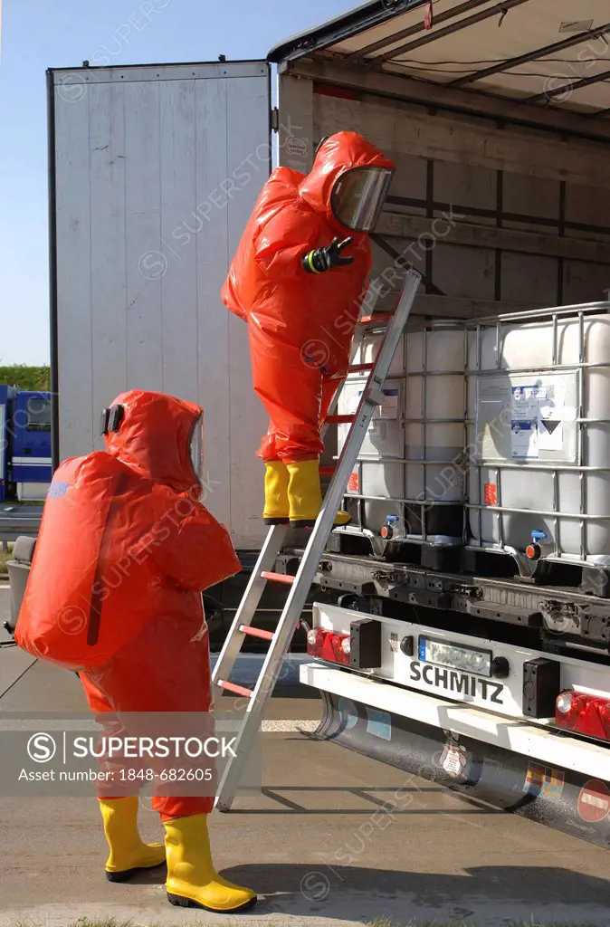Firefighters wearing protective suits while controlling the load of a truck carrying dangerous goods as part of a civil protection exercise on the A72...