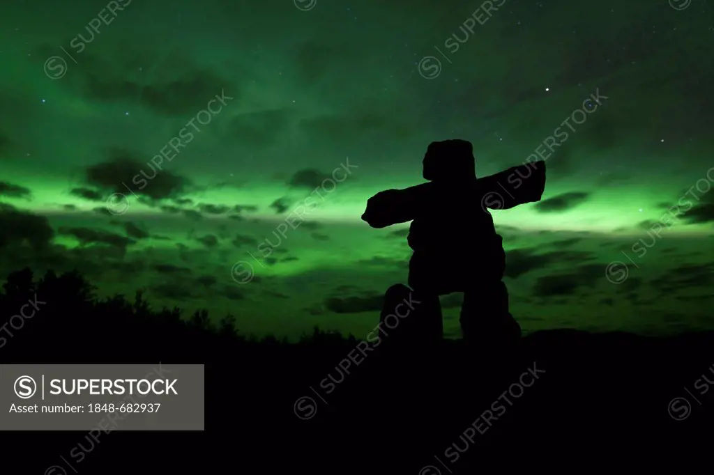 Silhouette of Inuit stone man, inukshuk, inuksuk, stone landmark or cairn, northern polar lights, Aurora Borealis, green, near Whitehorse, Yukon Terri...