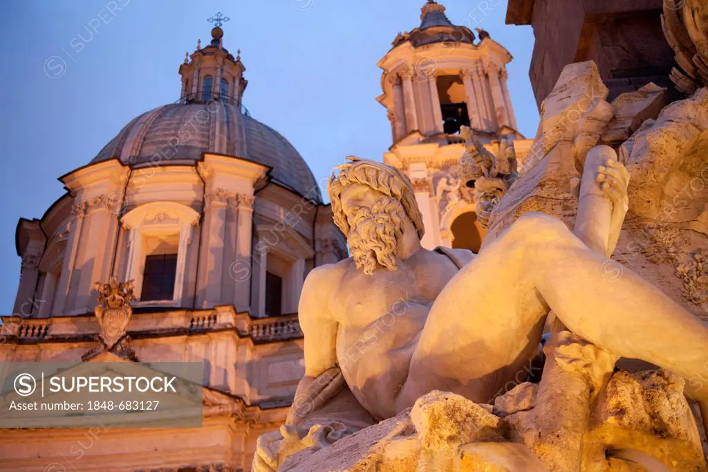 Statue of the Fontana dei Quattro Fiumi or Fountain of the Four Rivers and the church of Sant'Agnese in Agone at the blue hour on the Piazza Navona sq...