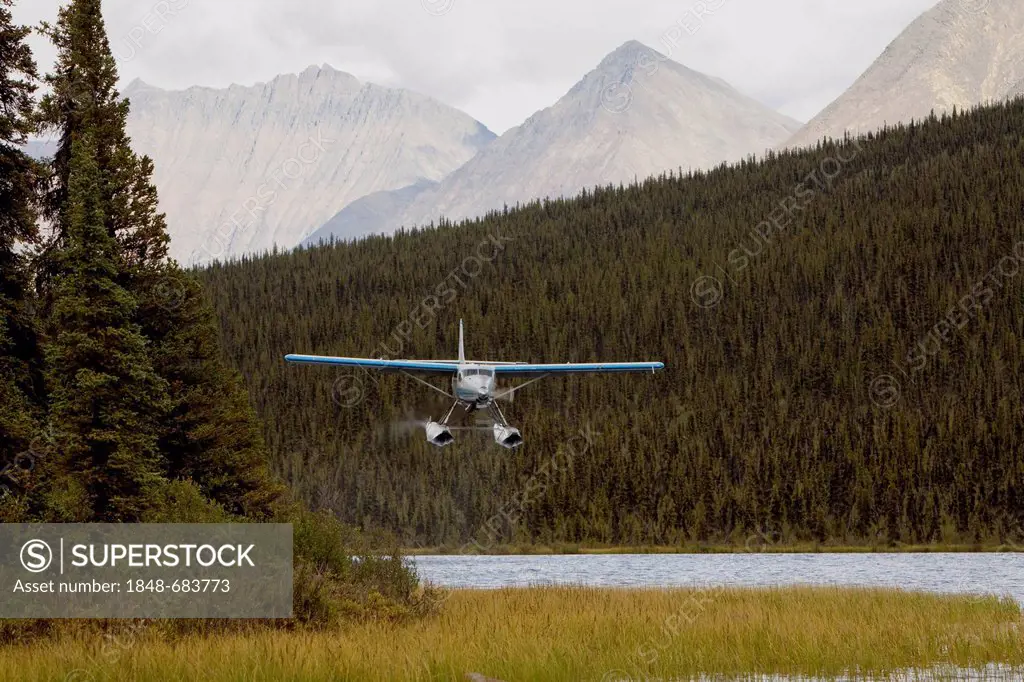 Bush plane, float plane de Havilland Canada DHC-3 Otter taking off from McClusky Lake, Wind River, Mackenzie Mountains, Yukon Territory, Canada