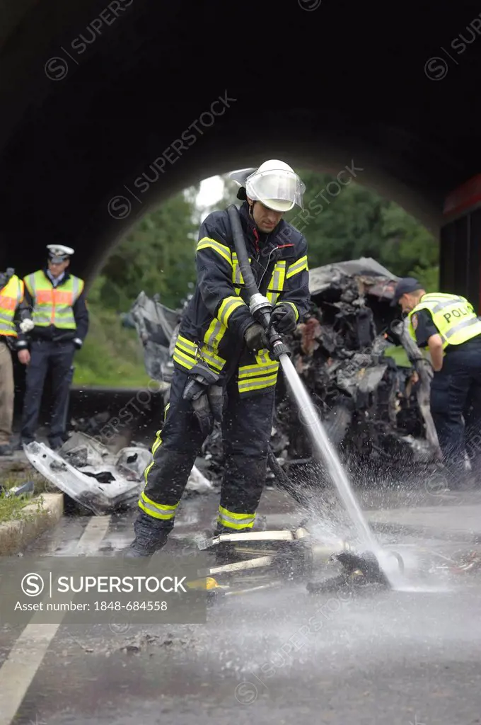 Firefighter cleaning hydraulic rescue equipment with a water jet after it had been used to recover a body of a road traffic accident, Sindelfingen, Ba...