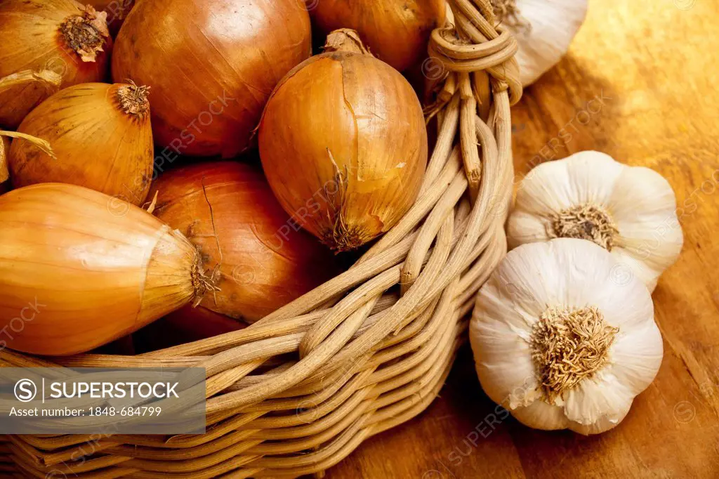 A basket of onions and garlic bulbs