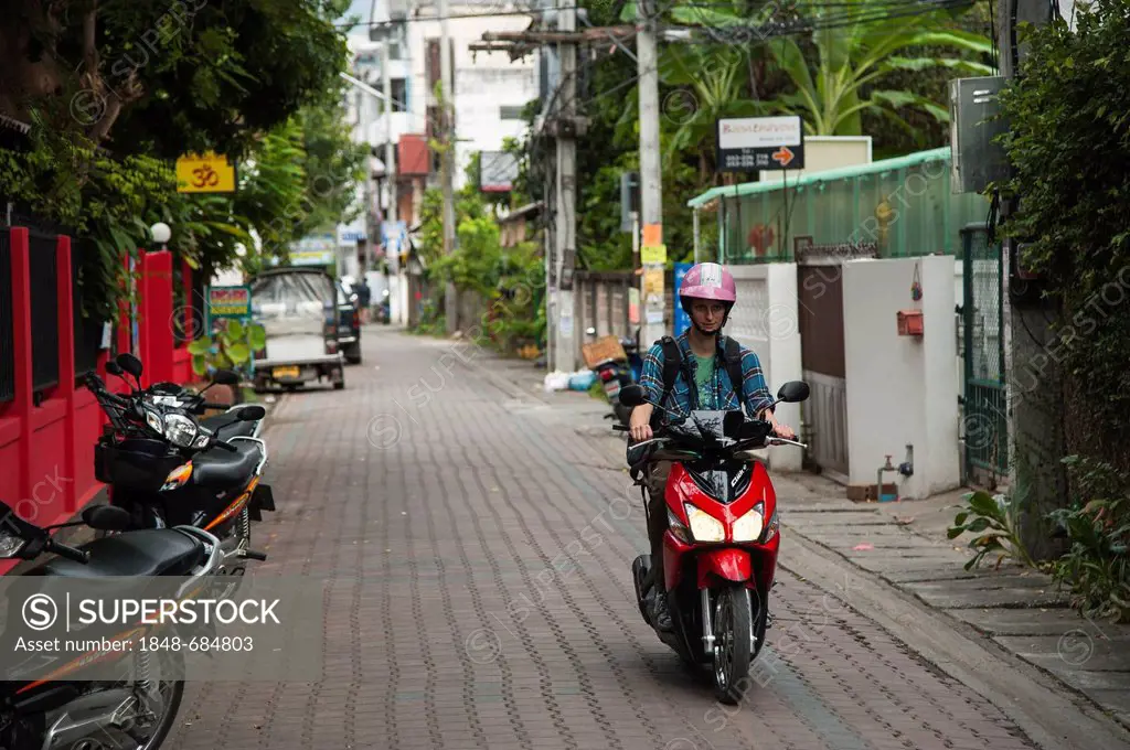 Woman riding a scooter, Chiang Mai, Northern Thailand, Thailand, Asia