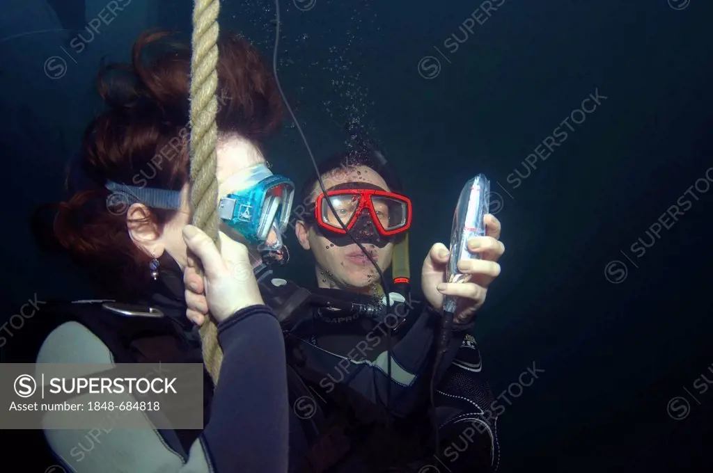 Girl sending SMS with mobile phone, under water, dolphinarium, Odessa, Ukraine, Europe