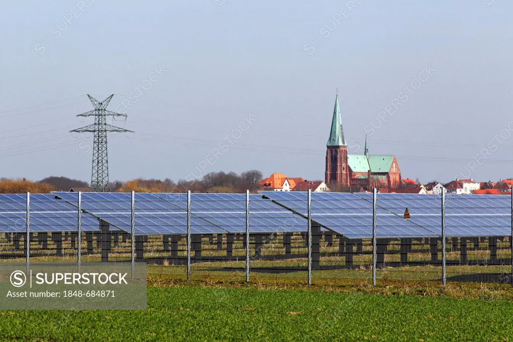 Solar power plant in a field in front of Meldorfer Cathedral, photovoltaic system, Meldorf, Dithmarschen, Schleswig-Holstein, Germany, Europe