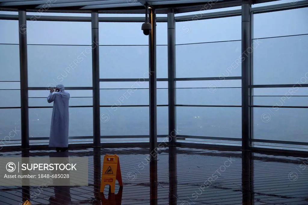 Solitary man on the observation deck of the tower Burj Khalifa in the rain, Dubai, United Arab Emirates, Middle East, Asia