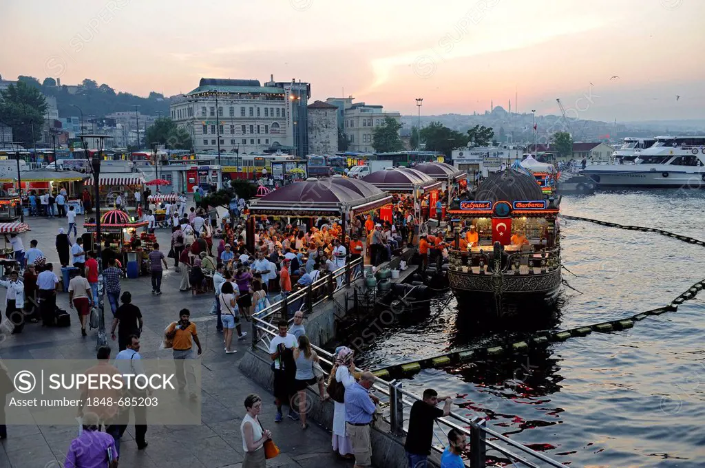 Floating fish restaurants, dusk, Eminoenue district, Golden Horn Bay, Halic, Istanbul, Turkey