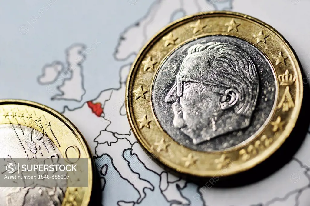 Belgian one-euro coin on a map, symbolic image for the debt crisis in Belgium