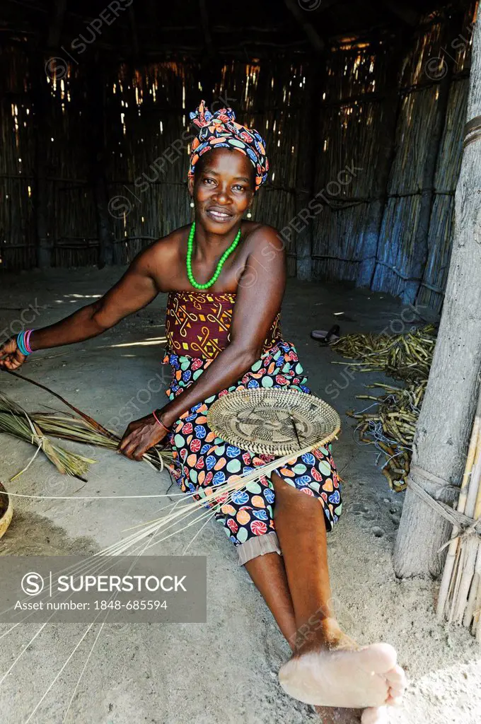 Woman demonstrating weaving in her hut on a guided tour of a traditional village near Camp Kwando on the Kwando River, Caprivi Strip or Okavango Strip...