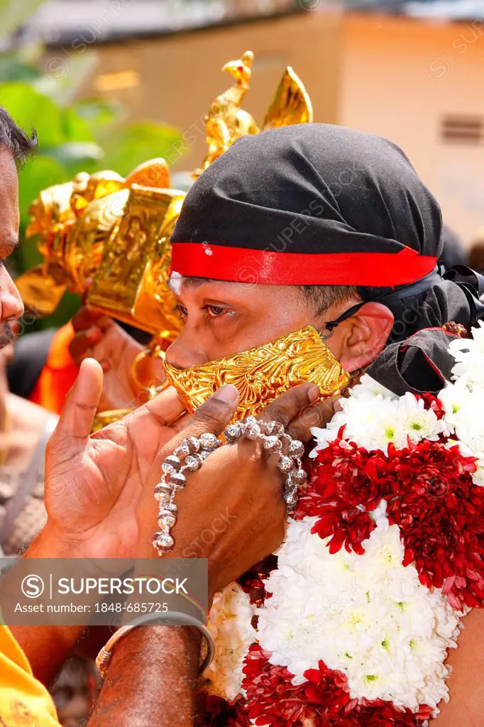 Holy man with sealed mouth and load on his shoulders, Hindu festival Thaipusam, Batu Caves limestone caves and temples, Kuala Lumpur, Malaysia, Southe...