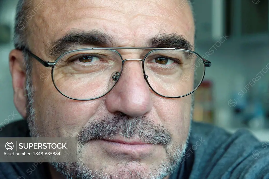 Senior man with glasses looking friendly, portrait