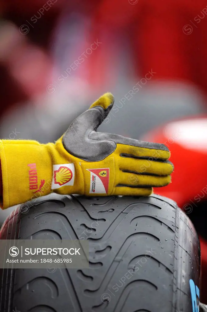 Ferrari mechanic's hand on the tyre of a race car giving the driver a sign, Formula 1, Belgian Grand Prix 2011, Spa-Francorchamps race track, Belgium,...