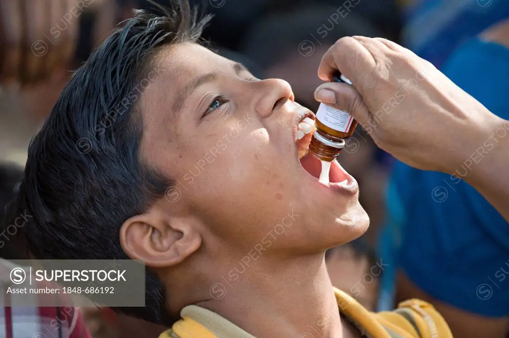 Boy getting an oral vaccination, vaccination campaign for children by the German Doctors for Developing Countries in Calcutta, Kolkata, West Bengal, I...