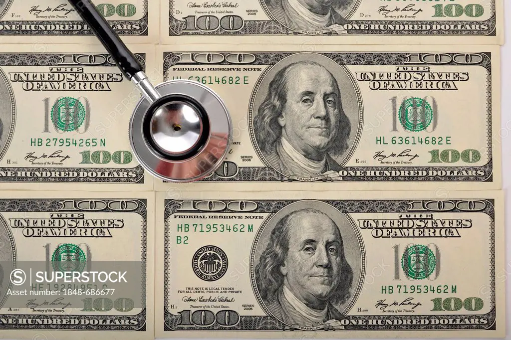 Stethoscope on U.S. dollar banknotes, symbolic image of a sick U.S. currency or the increasing cost of health care