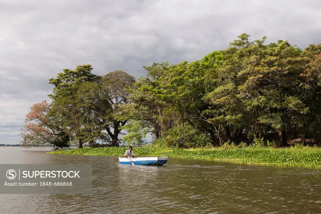 Boat in front of island with tropical vegetation in Lake Nicaragua, Isletas, Lago de Nicaragua, Nicaragua, Central America