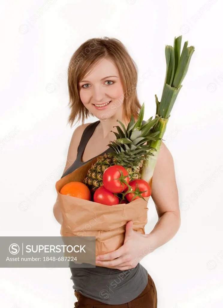 Young woman holding a bag of fruits and vegetables