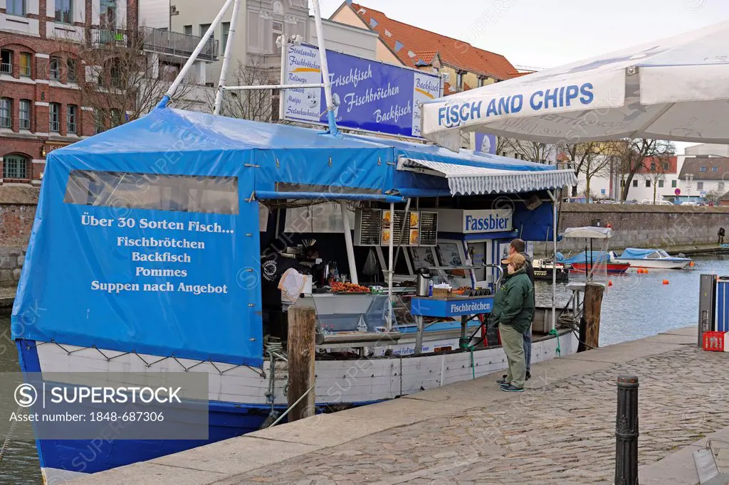 Fishing cutter selling fresh fish and fish bread-rolls in Querkanal, a canal in the historic port of Stralsund, UNESCO World Heritage Site, Mecklenbur...