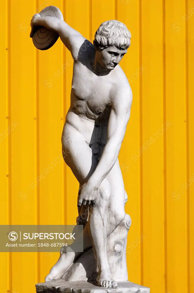 Sculpture of a Greek discus thrower, behind yellow metal panels, Herbolsheim, Baden-Wuerttemberg, Germany, Europe