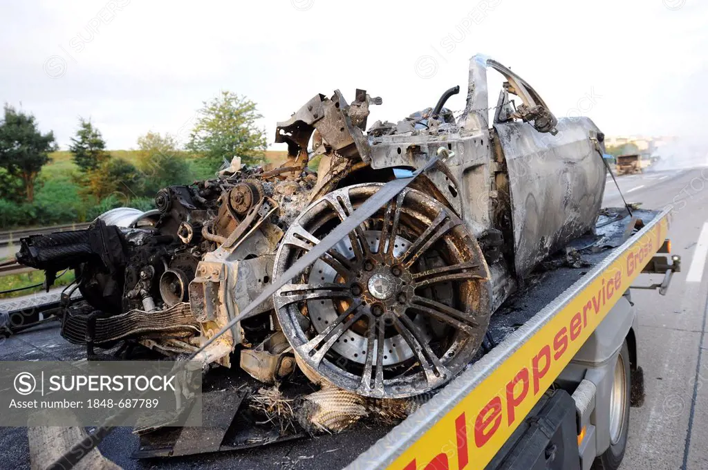 A burnt-out BMW M3 sports car on a tow truck on the A8 motorway, Stuttgart, Baden-Wuerttemberg, Germany, Europe