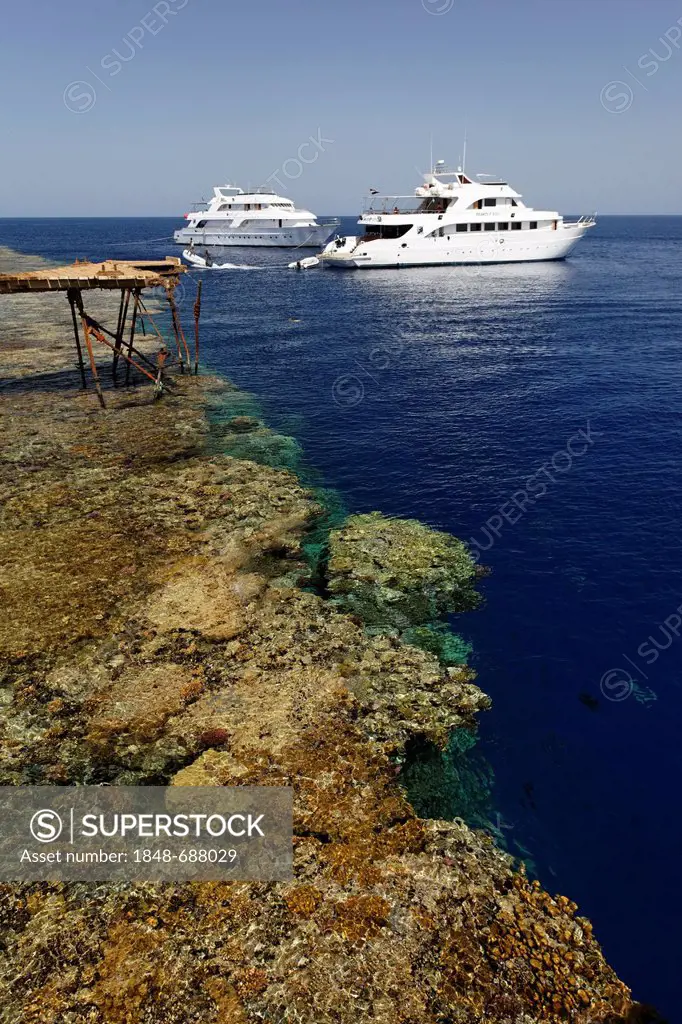 Dive ships anchor off the jetty in front of the reef top, Daedalus Reef, Egypt, Red Sea, Africa