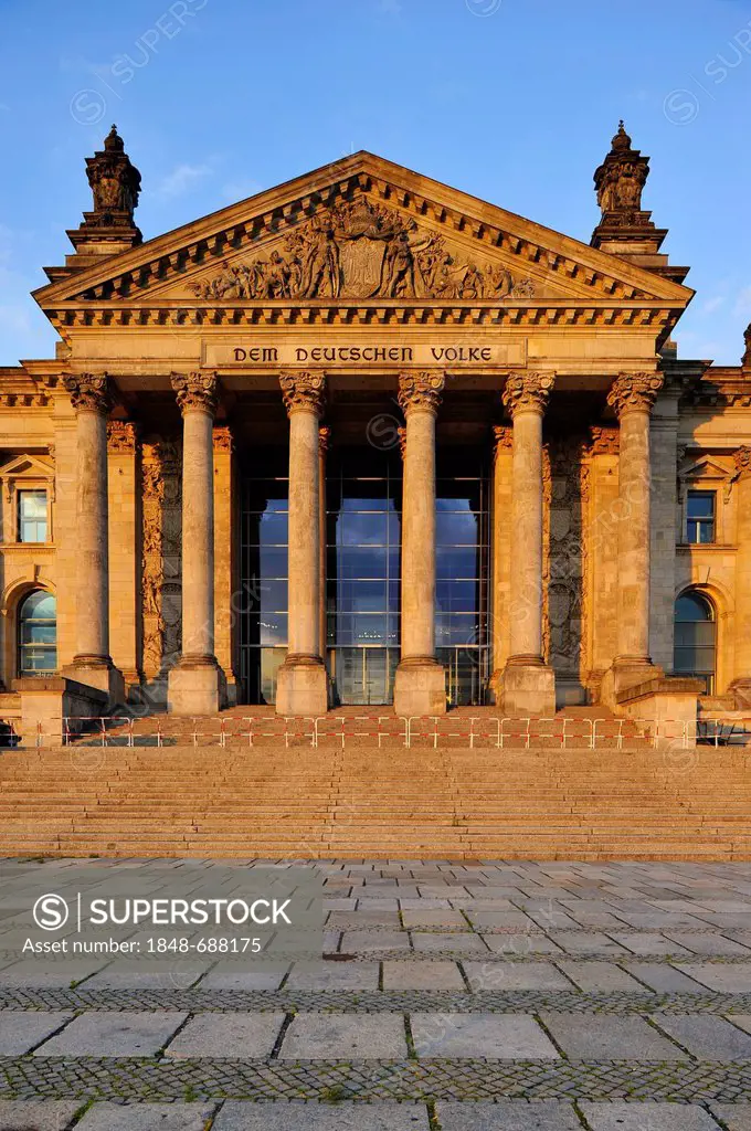 Evening light on the Reichstag German Parliament, words Dem Deutschen Volke or To the German People and relief in the tympanum over the main portal, G...