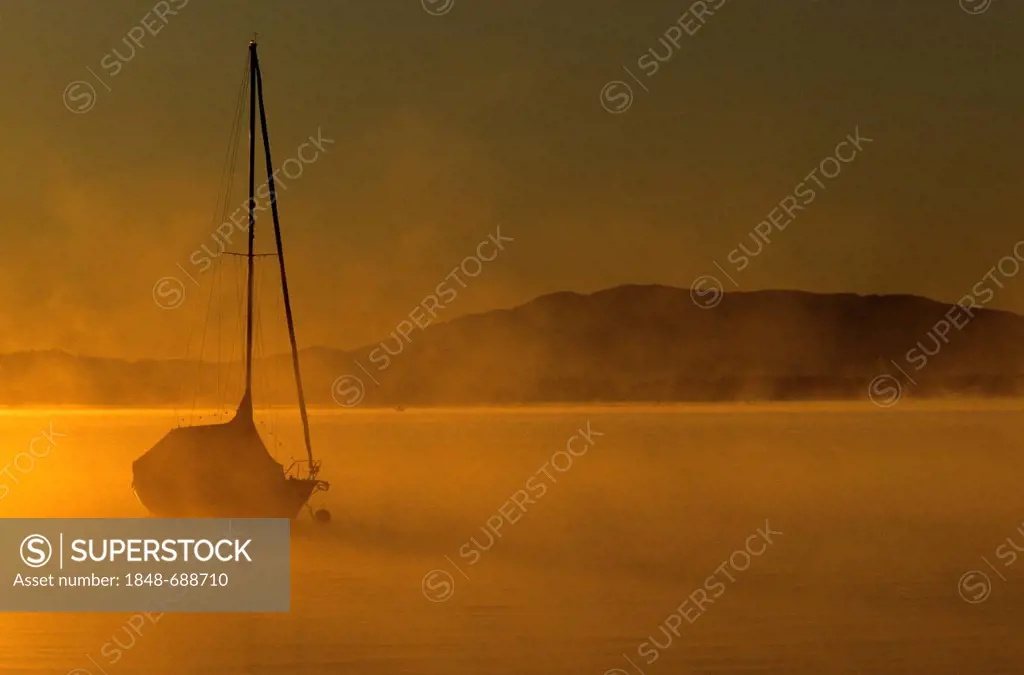 Boat in the early morning on lake Chiemsee, Chiemgau, Upper Bavaria, Germany, Europe