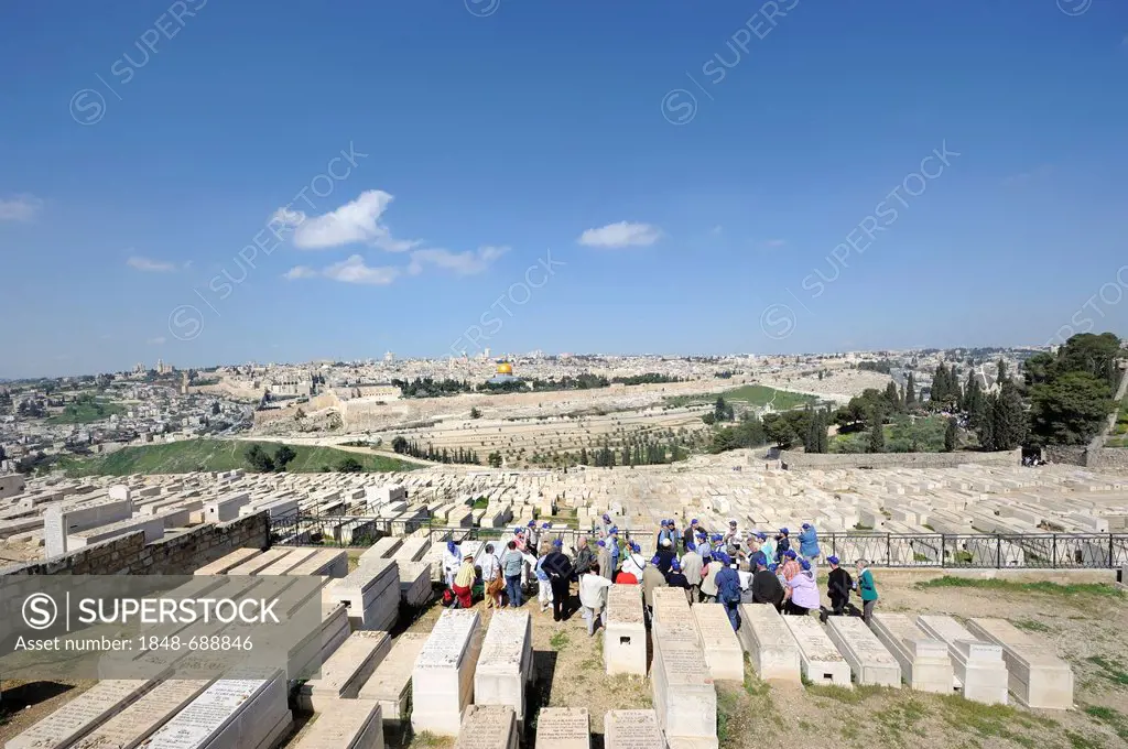Group of tourists on a guided tour through the Jewish cemetery on the Mount of Olives overlooking the old town of Jerusalem, Israel, Middle East