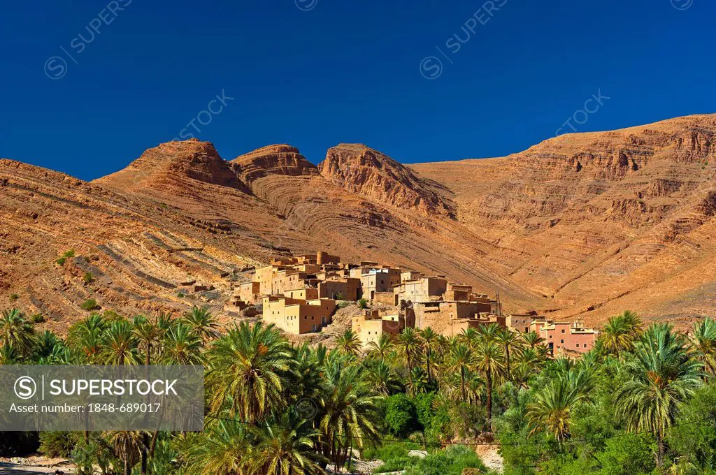 Typical cuesta landscape, mountain slopes characterized by erosion, with small settlements and date palms, Ait Mansour valley, Anti-Atlas Mountains, s...