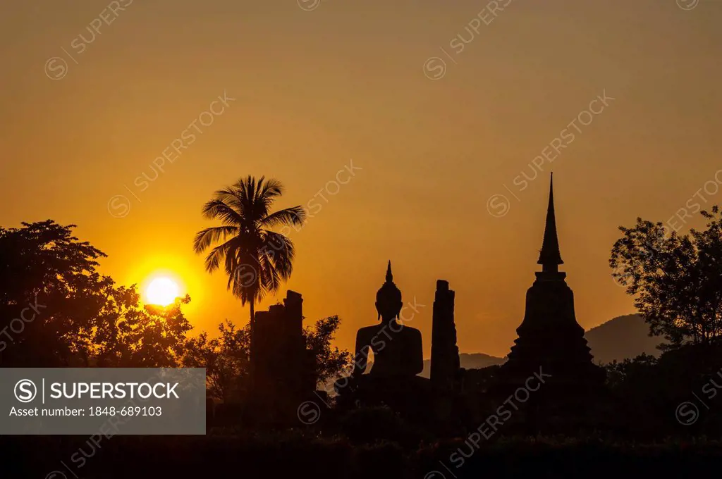 Silhouette of a seated Buddha statue at sunset, Wat Mahathat temple, Sukhothai Historical Park, UNESCO World Heritage site, Northern Thailand, Thailan...