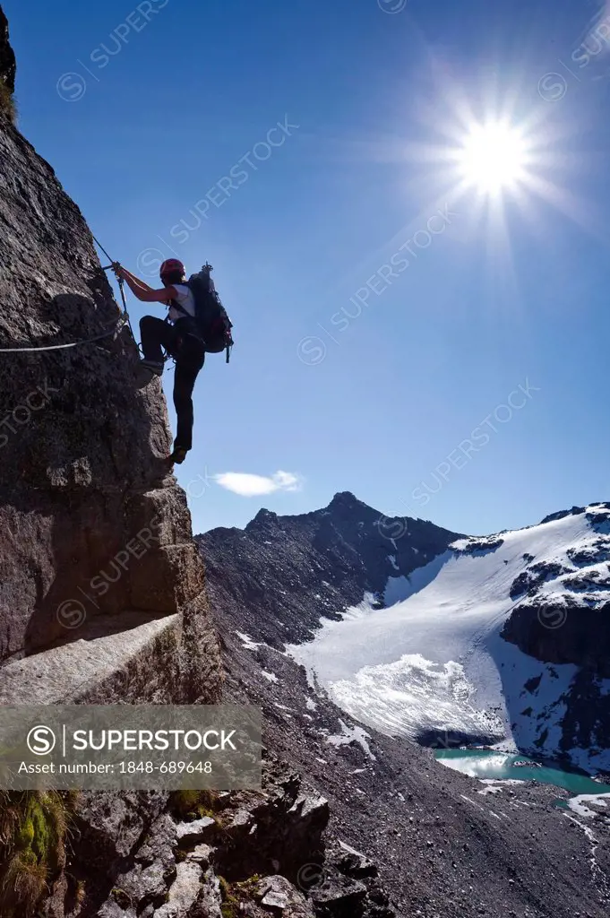 Climber using a climbing route while ascending to Tschenglser Hochwand Mountain above Duesseldorf Hut in Sulden, looking towards Kleine Angulus Mounta...