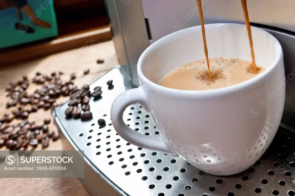Espresso coffee machine, espresso coffee pouring from a machine into a cup