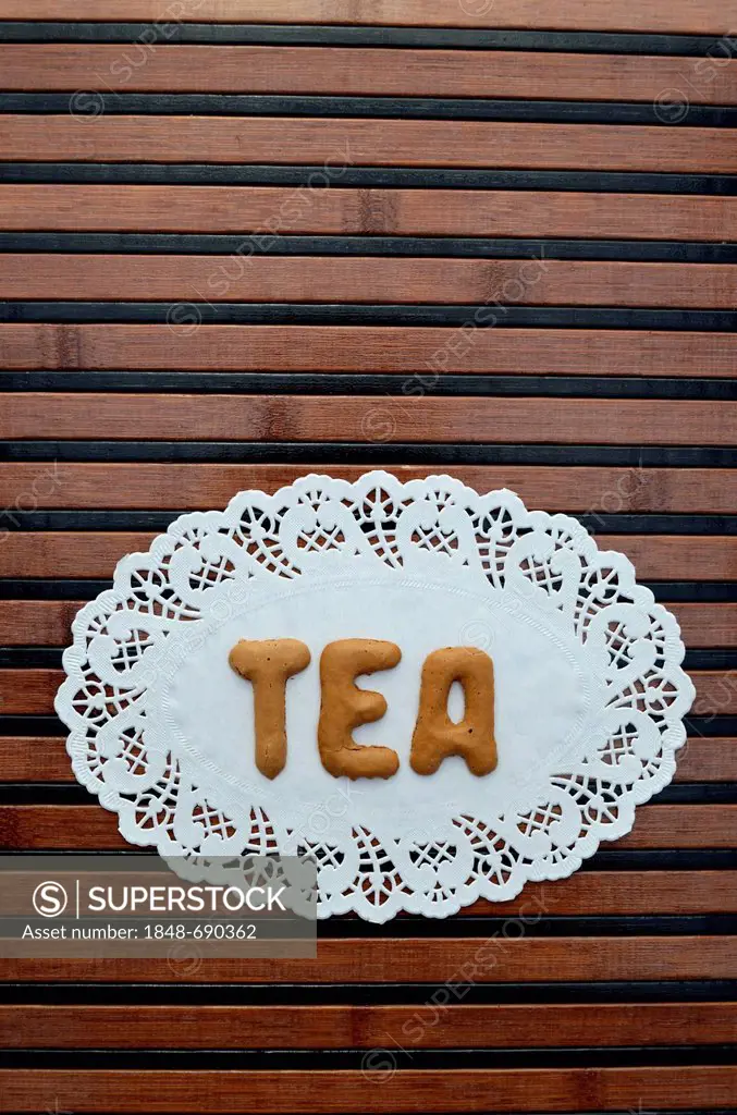 Tea, written with alphabet biscuits on a paper doily