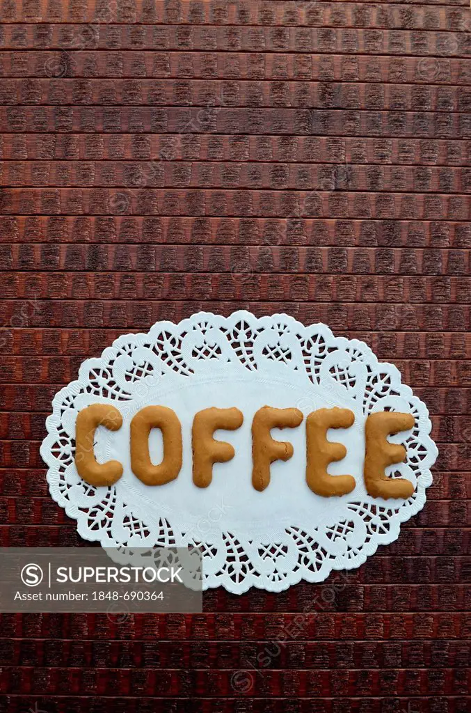 Coffee, written with alphabet biscuits on a paper doily