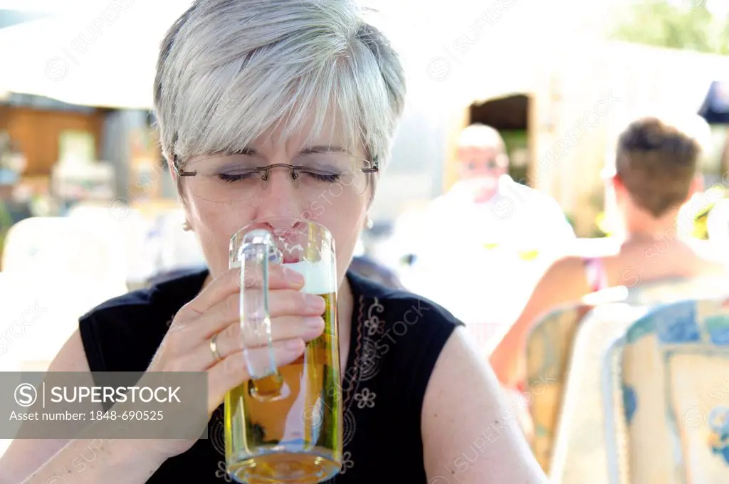Woman drinking a beer with eyes closed